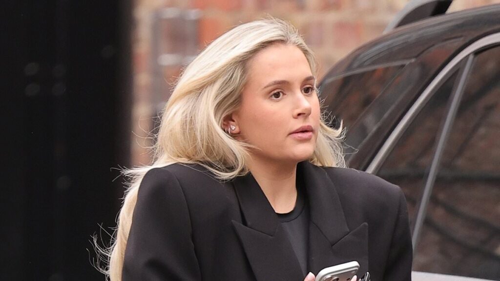 Pregnant Molly-Mae Hague covers her bump in a black coat as she steps out as rubbish piles up outside her office