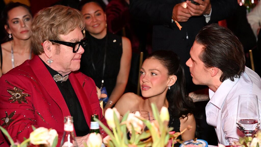 Elton John hosts godson Brooklyn Beckham and Nicola Peltz at his Oscars viewing party… after hot sauce influencer’s Mother’s Day swipe at Victoria