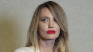 Angelina Jolie rocks a bold red lip with white robe and tousled blonde hair at Tom Ford event in China