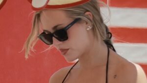 Lottie Tomlinson shows off her incredible figure in a black bikini as she soaks up the sun with shirtless Lewis Burton on the beach in Marbella