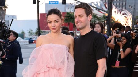 Miranda Kerr is pretty in pink as she joins VERY casually dressed husband Evan Spiegel at high-fashion Dior show – after revealing beauty secrets