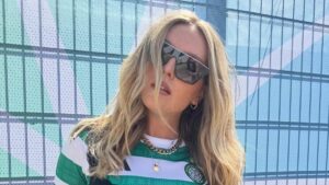 Perrie Edwards wows in a lacy black corset top as she pays tribute to her new husband Alex Oxlade-Chamberlain while posing in his football shirt during festival shows