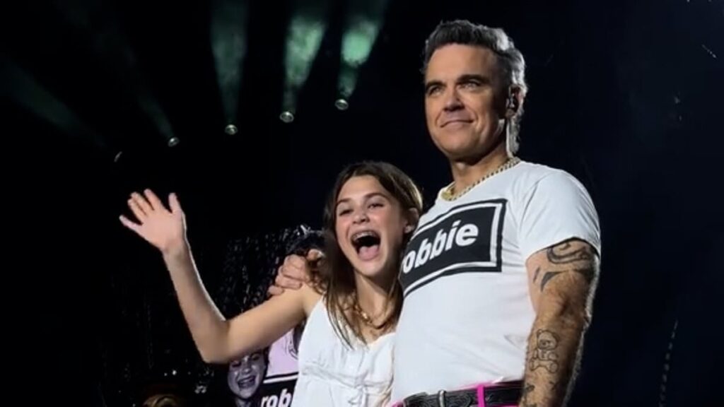 Robbie Williams sweetly brings his rarely seen daughter Teddy, 13, on stage in Luxembourg during his Britpop Tour – after revealing she is set to follow in his footsteps with her ‘wonderful voice’