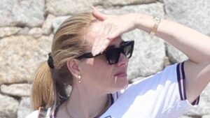 Adele shows her support for footballer John Stones by wearing a number five England shirt while in Sardinia with fashion designer Tom Ford